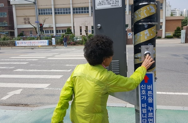 한 주민이 영신중학교 앞 횡단보도에 설치한 버튼식 보행자 작동 신호등을 이용하고 있다.