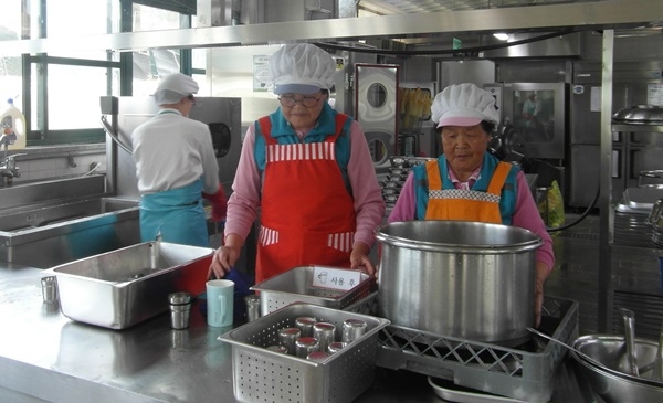 초등학교 급식도우미 사업에 참여한 어르신들이 급식 보조 활동을 하고 있다.