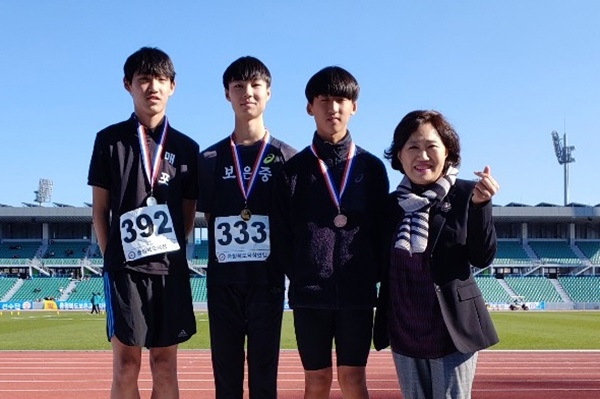 교육감기 육상경기대회 남중부 높이뛰기와 멀리뛰기에서 금메달을 딴 보은중 김현식 선수(시상대 가운데)가 박인자 보은교육장의 축하를 받고 있다.