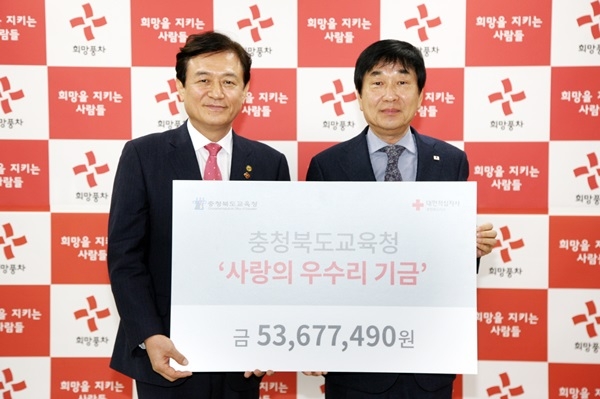 김병우 충북도교육감(왼쪽)이 김경배 대한적십자사 충북지사 회장에게 사랑의 우수리 기금 5368만원을 전달하고 있다.