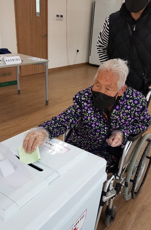 옥천군 최고령 유권자인 이용금 할머니(116)가 15일 오전 청산면 삼방리 팔음산 마을회관에 마련된 투표소에서 투표용지를 투표함에 넣고 있다.