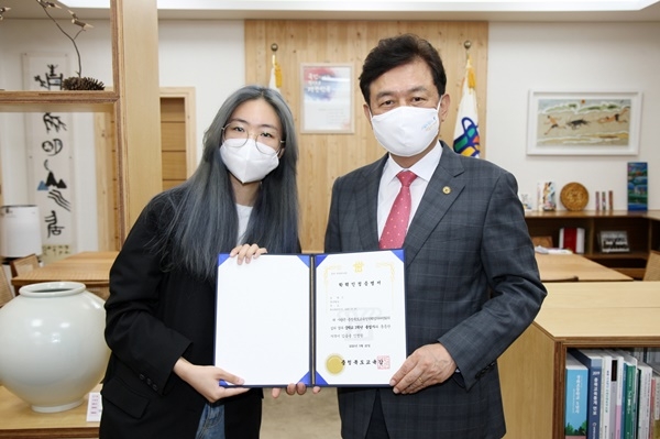 김병우 충북교육감(오른쪽)이 신예현양에게 중학교 졸업 학력인정 증명서를 수여한 뒤 기념촬영을 했다. /충북도교육청 제공
