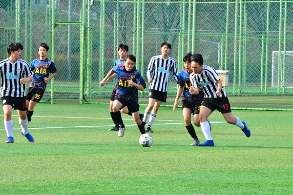 청주 주성고(줄무늬 유니폼)와 봉명고의 경기에서 선수들이 공을 차지하기 위해 몸싸움을 벌이고 있다.