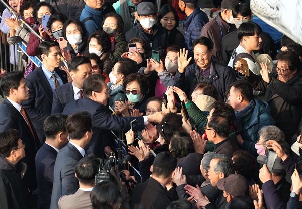 윤석열 대통령이 26일 충남 서산 동부 전통시장을 방문한 뒤 떠나며 시민들과 인사하고 있다./연합뉴스